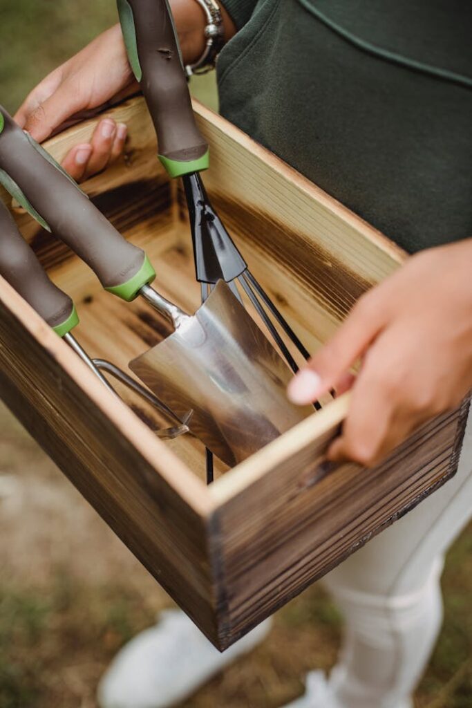 pexels-photo-5529583 Crop farmer with gardening tools in wooden container